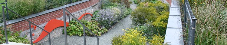 In diesem Teil einer Gartenanlage wurde eine Unterwasserszene aus blauem Kies, orangen Fischen auf Stäben sowie verschiedenen Gräsern und abgerundeten Steinen nachgebildet.